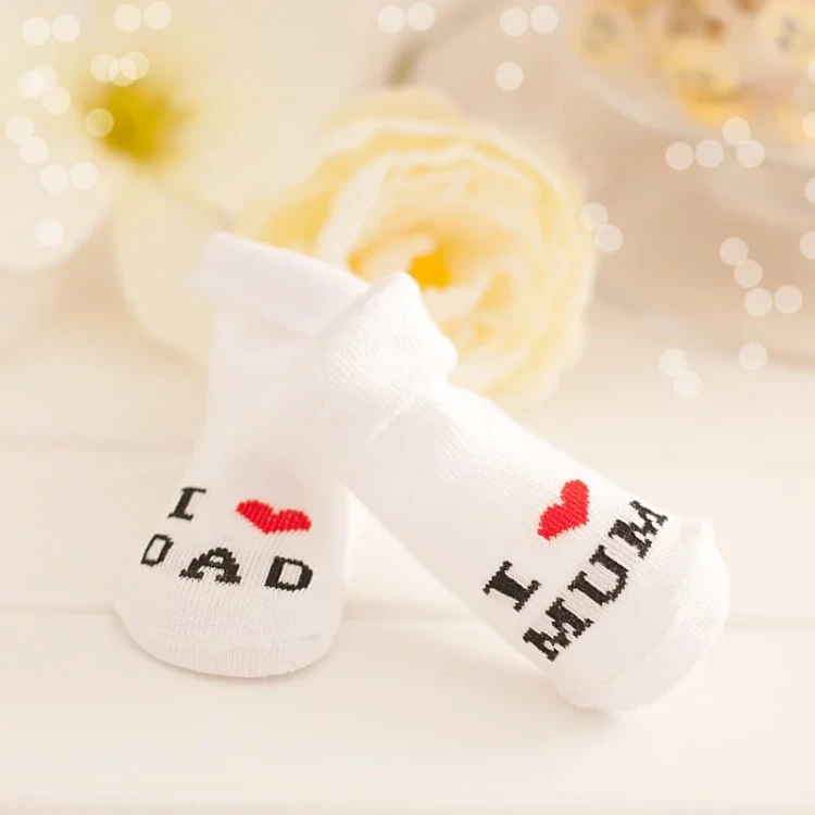 Białe skarpetki niemowlęce z nadrukiem I love Mum i I love Dad w uroczym stylu.