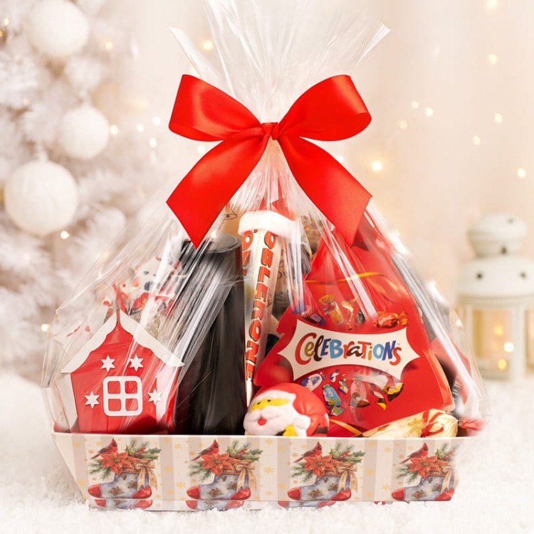 Elegancko zapakowany kosz świąteczny z piernikami, marcepanem i akcesoriami.