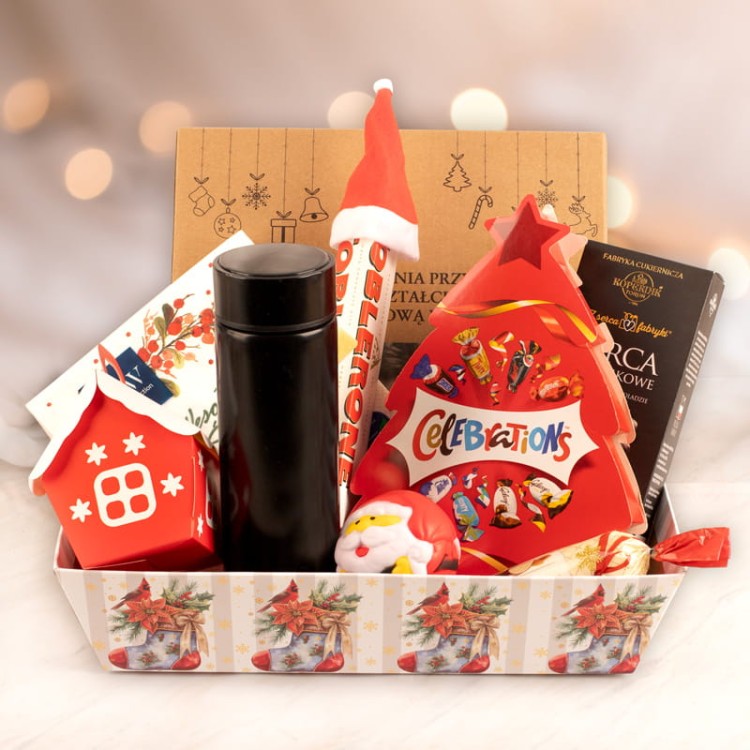 Kosz świąteczny z czekoladowymi słodkościami i bożonarodzeniowymi dodatkami.