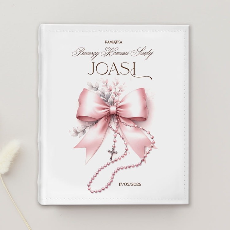 Album personalizowany na Komunię dziewczynki. Na okładce grafika przedstawiająca kokardę i różaniec.