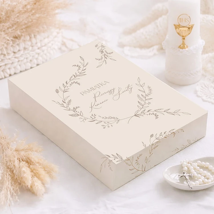 Opakowanie prezentowe na Komunię Świętą w jasnej kolorystyce z subtelną grafiką. Doskonałe do eleganckiego wręczenia Biblii komunijnej.