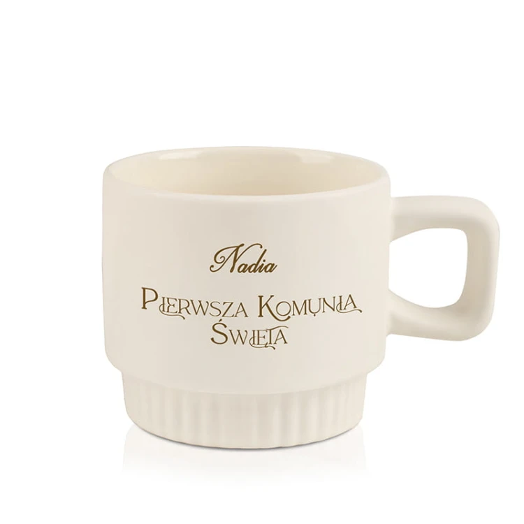 Personalizowany prezent komunijny w postaci kubka z imieniem.