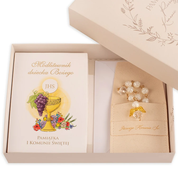 Zestaw komunijny dla dziecka. W środku znajduje się modlitewnik, różaniec i koperta.