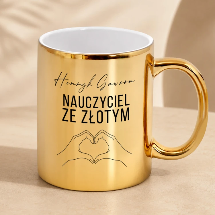 Złoty kubek dla nauczyciela z personalizacją imienia i nazwiska oraz grafiką serca.