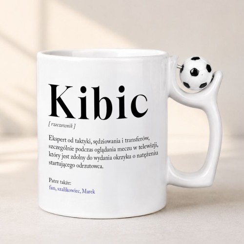 Kubek z Piłką w Uchwycie i Definicją Słowa Kibic wykonany z białej ceramiki dla fana piłki nożnej.
