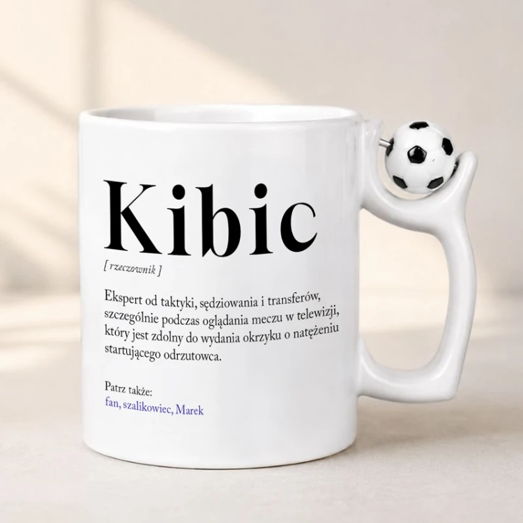 Kubek z Piłką w Uchwycie i Definicją Słowa Kibic wykonany z białej ceramiki dla fana piłki nożnej.