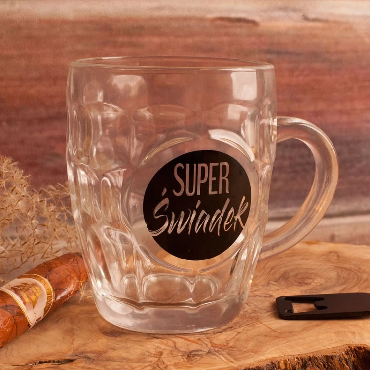 Kufel na prezent dla świadka ma dekoracyjne szkło oraz czarny nadruk „Super Świadek”.