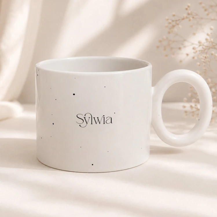 Biały ceramiczny kubek z personalizowanym imieniem.