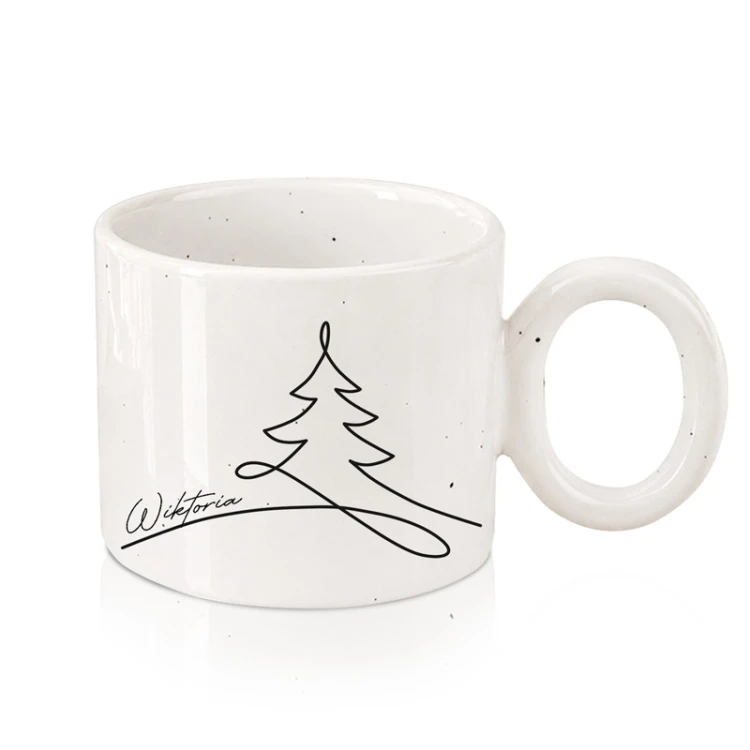 Personalizowany ceramiczny kubek z choinką i imieniem na białym tle.