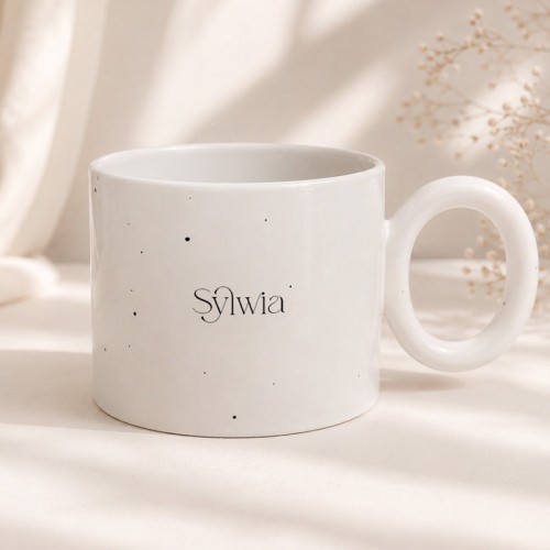 Biały ceramiczny kubek nakrapiany z personalizowanym imieniem.