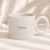Biały ceramiczny kubek nakrapiany z personalizowanym imieniem.