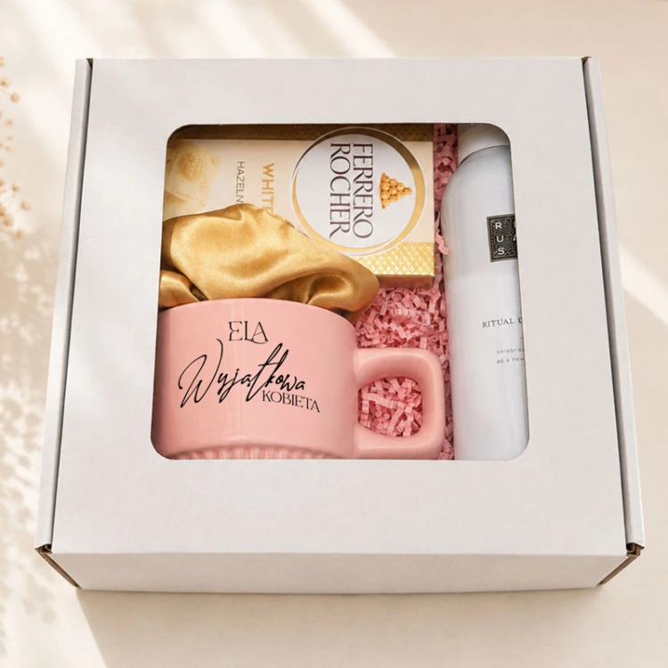 Box prezentowy z okienkiem zawierający personalizowany kubek i kosmetyki.