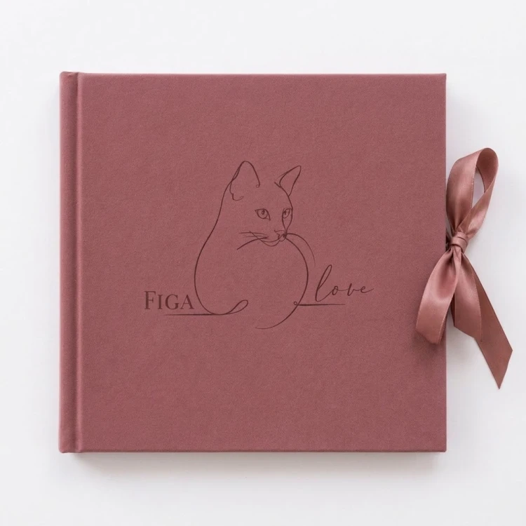 Personalizowany różowy album na zdjęcia z imieniem kota i minimalistycznym grawerem.