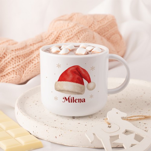 Personalizowany kubek dla dziecka na Mikołajki z imieniem, czapką Mikołaja i śnieżynkami.