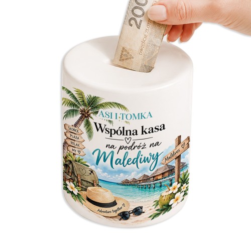 Biała skarbonka z imionami pary i tropikalną grafiką przedstawia wakacje na Malediwach.