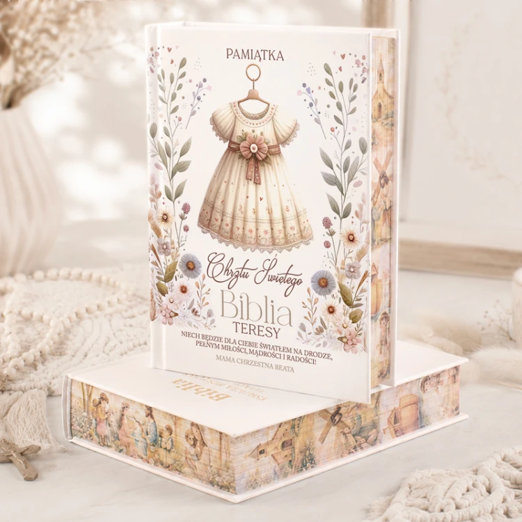 Personalizowana Biblia na Chrzest Święty dla dziewczynki z imieniem i dedykacją od matki chrzestnej, ozdobiona kwiatami i ilustracją sukienki.