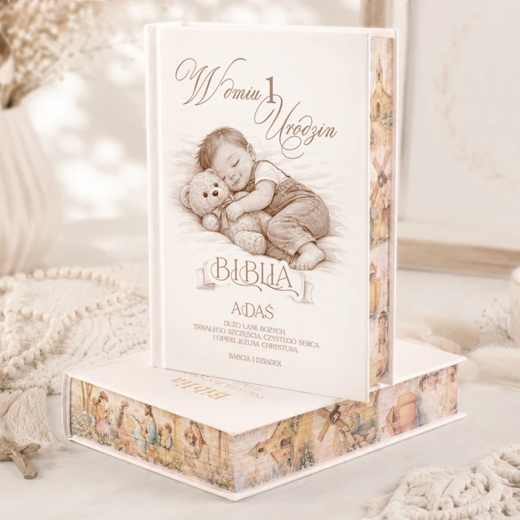 Personalizowana Biblia na pierwsze urodziny chłopca z imieniem, dedykacją od dziadków i ilustracją śpiącego dziecka z misiem. Pamiątka na roczek.