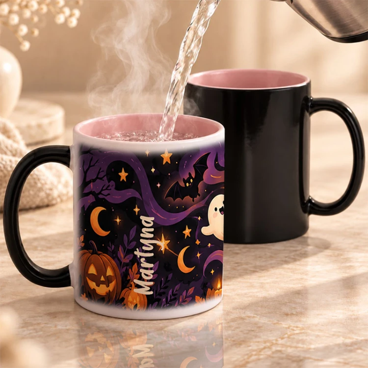 Czarny kubek z różowym wnętrzem zmienia wygląd pod wpływem temperatury i pokazuje halloweenowy nadruk.