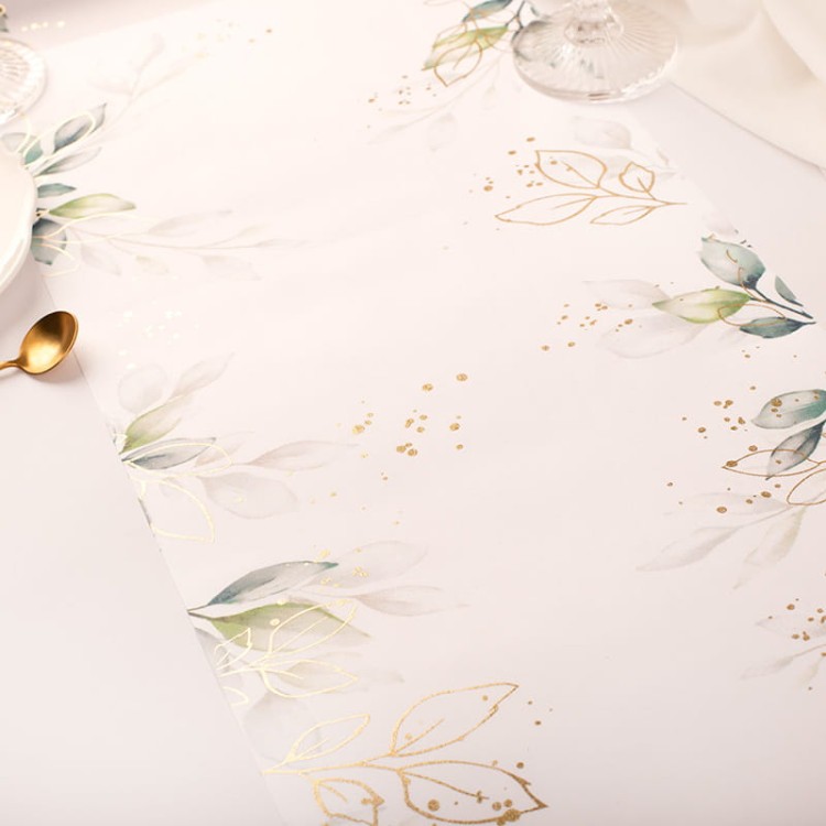 Bieżnik na chrzest wykonany z materiału z eleganckim motywem liści.